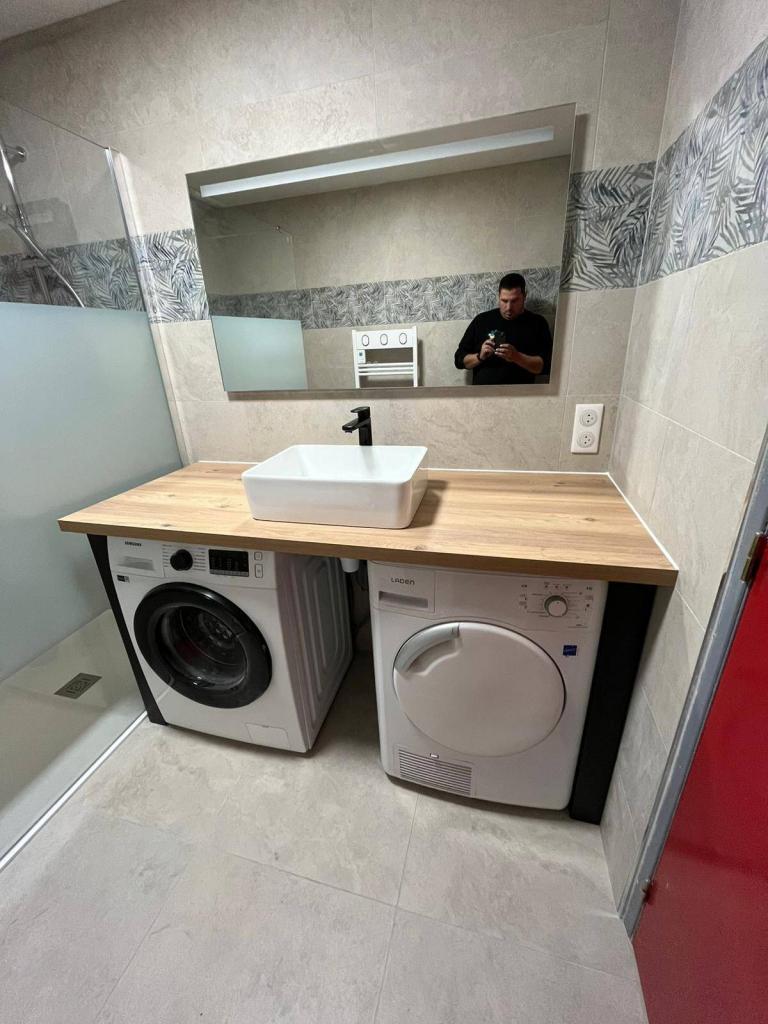 Meuble vasque et espace buanderie intégrés dans une salle de bain rénovée