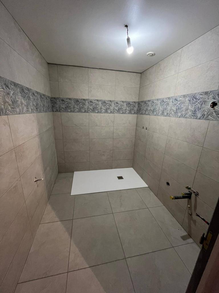 Espace douche rénové avec bac à douche et carrelage mural par JSA CLIM